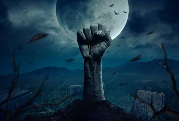 istock Zombie hands rising in dark Halloween night. 997750840