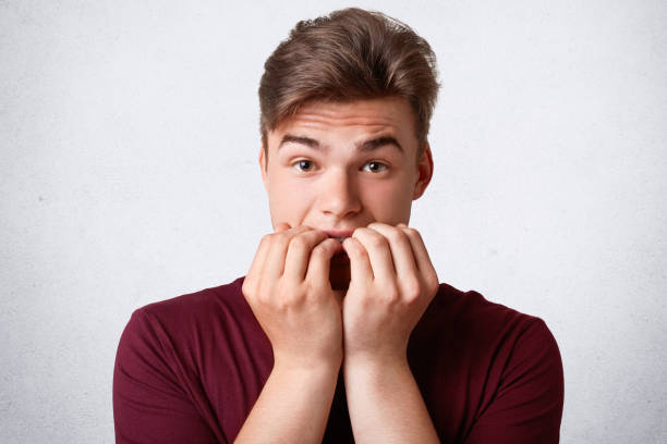 istock Nervous Caucasian male bites finger nails and feels embarrassed before important event, dressed in casual outfit, isolated over white background. Stressful depressed man with trendy hairstyle 997751636