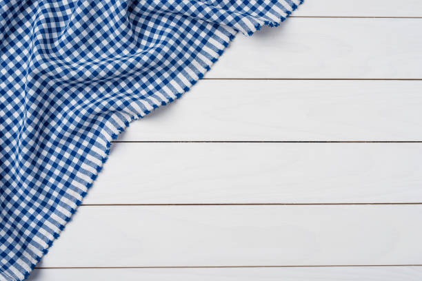 Blue checkered tablecloth on an old wooden table. Close up stock photo