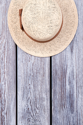 Top view straw hat. Grey desk surface background.