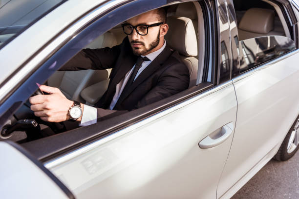 istock handsome driver in suit and glasses driving car 997779242