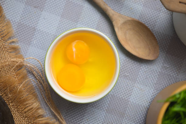 istock Two chicken raw egg yolks in white dish. Top view 997787426