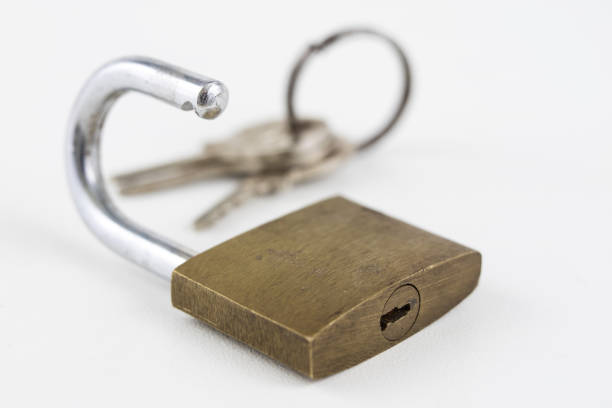 Brass padlock on a white table. Accessories for locking and securing against burglary. White background.
