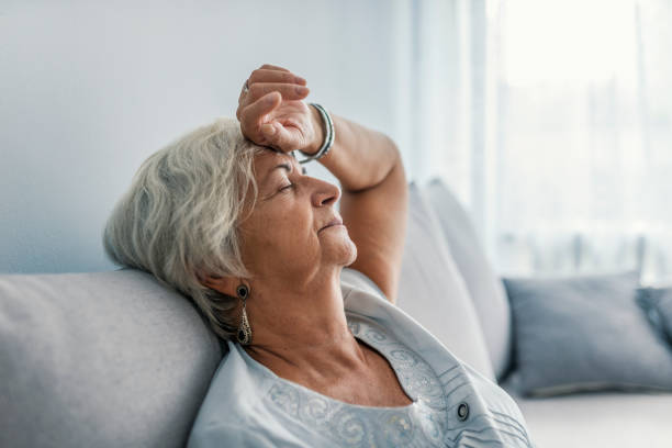 Thoughtful senior woman relaxing on bed. Thoughtful senior woman relaxing on bed. Senior woman relaxing at home. Woman having a nap on the sofa relaxing with her head tilted back on the cushion and eyes closed tired stock pictures, royalty-free photos & images