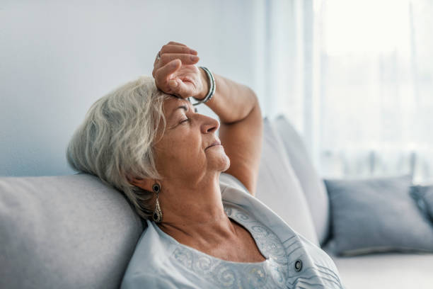 thoughtful senior woman relaxing on bed. - exaustão imagens e fotografias de stock