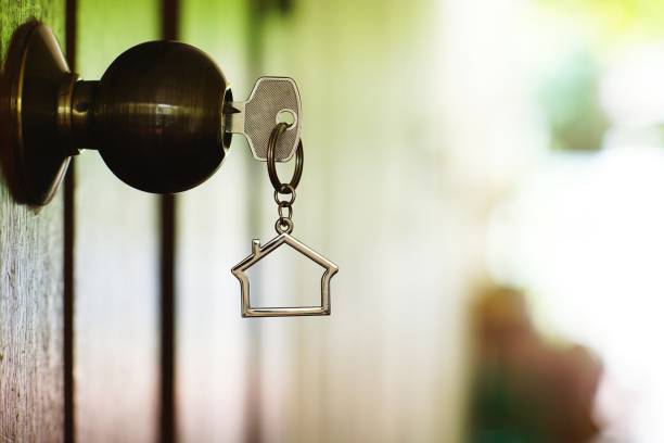 Home key with house keyring in keyhole, copy space, property concept stock photo