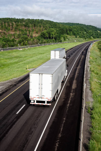 istock Trucks Moving Down Interstate Highway, Tractor Trailer Trucking 997791612
