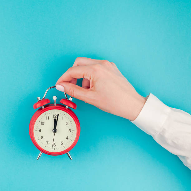 istock Woman hand holding the red vintage alarm clock 997792012