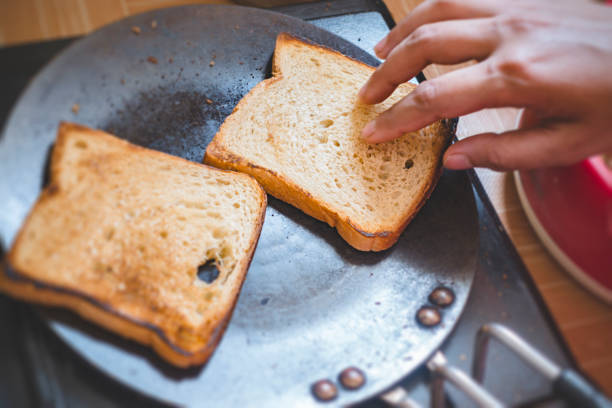 istock Close-up of hands make bread toast on Tawa. 997792130