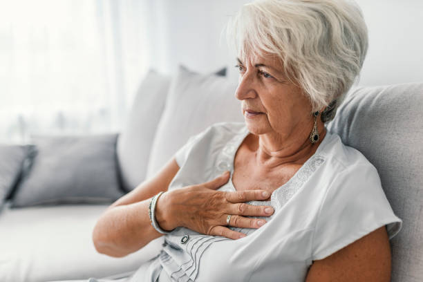 senior woman suffering from heartburn or chest discomfort symptoms - chest pain imagens e fotografias de stock