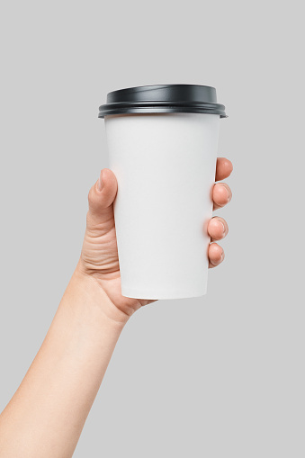 istock Mockup of women's hand holding white paper large size cup with black cover 997807968
