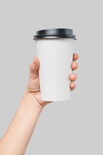 makieta damska ręka trzymająca biały papier duży kubek z czarną pokrywą - disposable cup cup paper disposable zdjęcia i obrazy z banku zdjęć