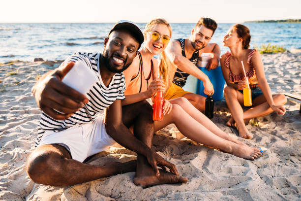 istock happy young multiethnic friends taking selfie with smartphone while spending time together on sandy beach 997813522