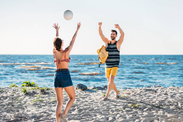 istock happy young couple playing volleyball on sandy beach 997813748