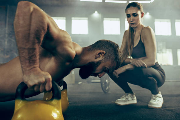 istock Fit young man lifting barbells working out in a gym 997816728