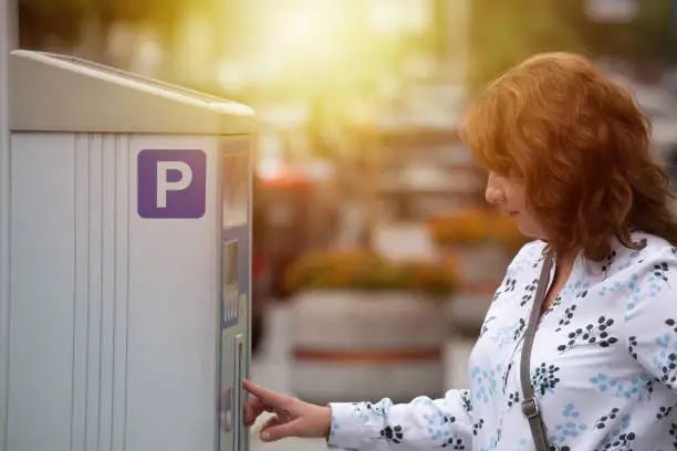 Photo of Woman using parking meter