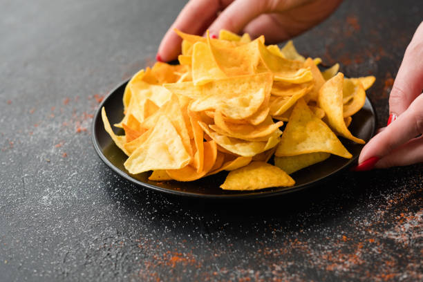 istock junk fast food eating chips woman hands bowl 997818012