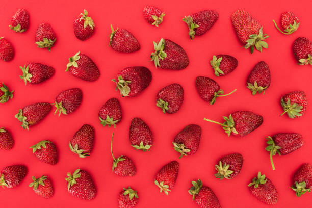istock top view of raw strawberries isolated on red background 997835320