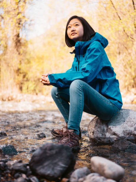 A Japanese woman hiker take a break while exploring a wilderness area in Utah, USA.