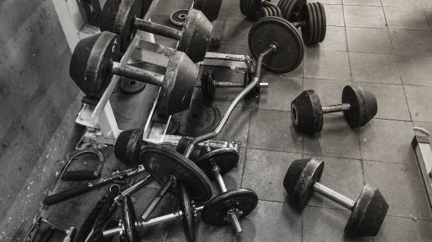 istock Dumbbells on Rack and Weights on Floor in Gym 997876702