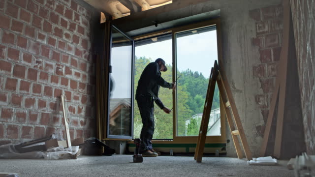 LD Male worker adjusting the balcony door after installation