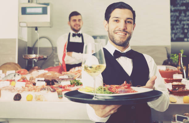 istock Waiter with serving tray in fish restaurant 997907936