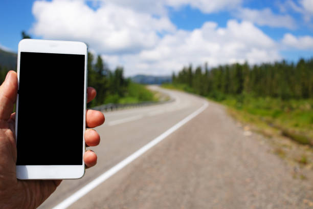 istock Mockup image of a man using smart phone with blank black screen on road 997910638