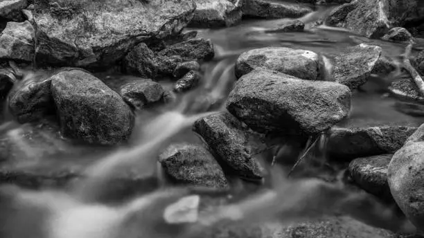 Water Flowing over rocks in a stream bed in B&W