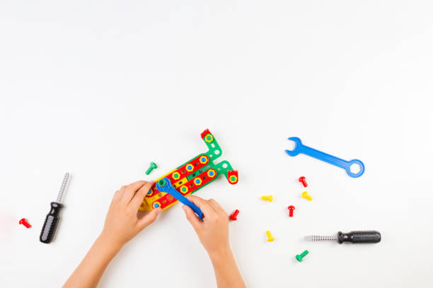 istock Child's hands playing with colorful toys tools on the white background. 997941134