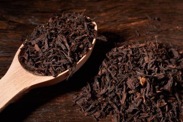 istock Beautiful tea in a wooden spoon on a black background. Isolated 997949746
