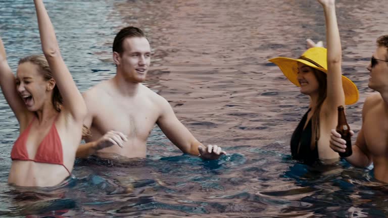 Group Of Friends On Vacation And Enjoyment Into Outdoor Pool