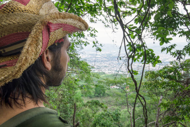 istock Male explorer observing city through window in vegetation on hil 997955782