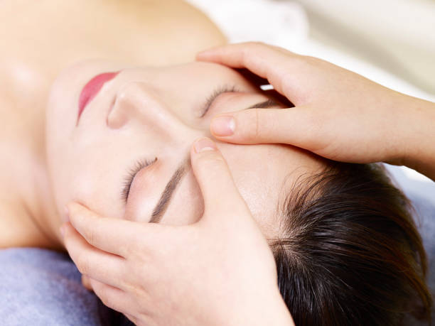 istock young asian woman enjoying a face massage 997956332