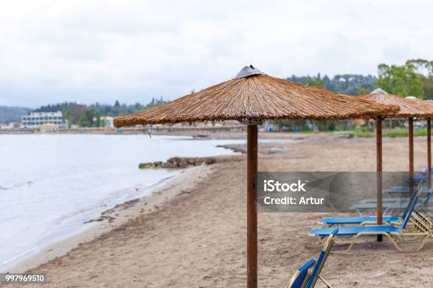 Bonita Umbrella Piling Up In The Beach Portable Lazy Chairs Diplay Under The Hut And Facing The Shoreline Resort Amenities For Guest And Rentals Concept Stock Photo - Download Image Now