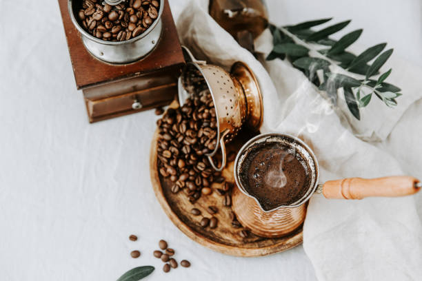 Hot coffee in Turkish Cooper and coffee beens on linen table Hot coffee in Turkish Cooper and coffee beens on linen table turkish coffee pot cezve stock pictures, royalty-free photos & images