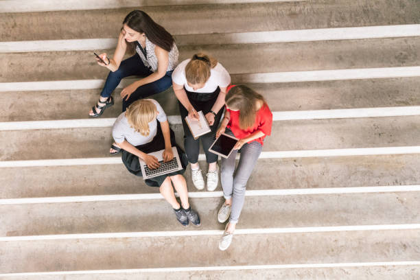 istock top view of urban people holding technologies while sitting on steps 998008642