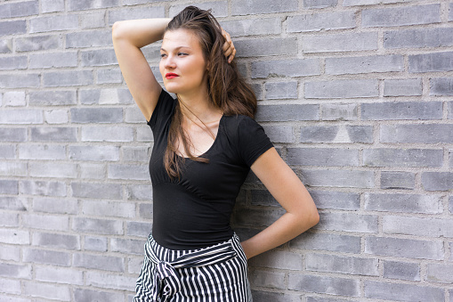 Confident woman leaning against the wall