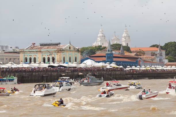 Fluvial Cirio Belém, PA, Brazil - October 12th, 2013: A crowd and many boats follow the image of Our Lady of Nazareth to the waters of Guajará Bay as part of the celebrations of the Cirio de Nazareth, considered the largest Catholic event of the world. On the background there are the towers of the Our Lady of Nazareth's Basilica. cirio de nazare stock pictures, royalty-free photos & images