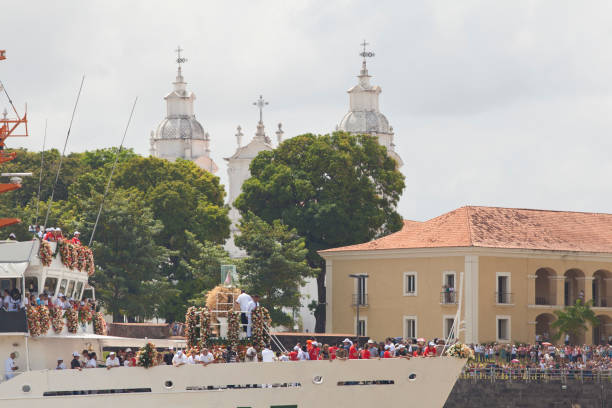 Fluvial Cirio with military ship Belém, PA, Brazil - October 12th, 2013: A crowd watch the image of Our Lady of Nazareth taken by military ship by the waters of Guajará Bay as part of the celebrations of the Cirio de Nazareth, considered the largest Catholic event of the world. On the background there are the towers of the Our Lady of Nazareth's Basilica. cirio de nazare stock pictures, royalty-free photos & images