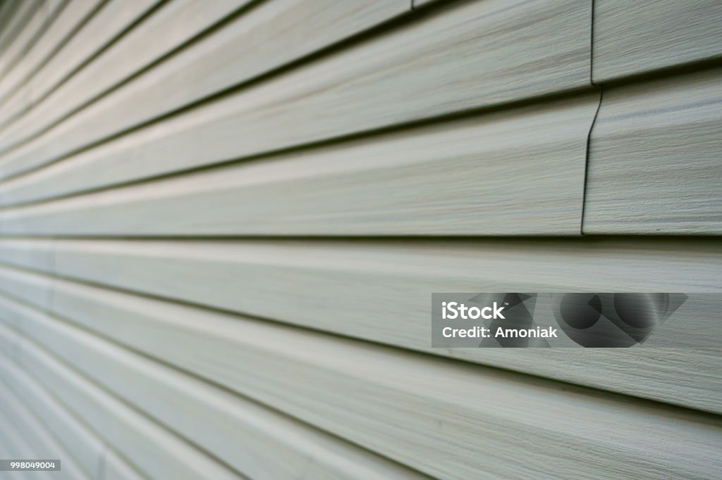 A graphical vinyle exterior wall. Tiles of vinyle covering an exterior wall of a residential home in North America in order to isolate the house from the cold winter season. Siding - Building Feature Stock Photo