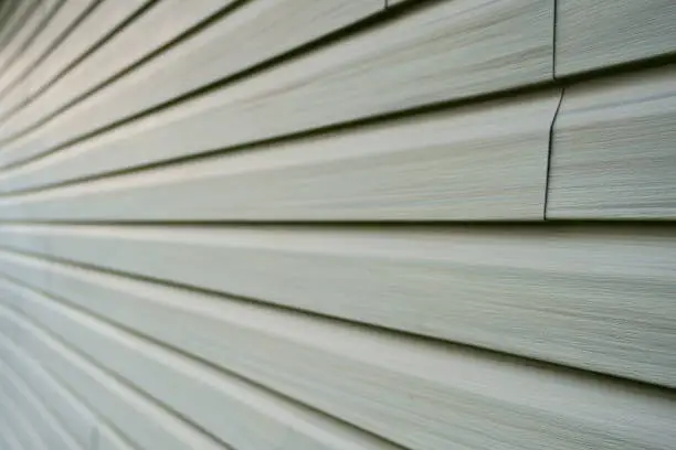 Tiles of vinyle covering an exterior wall of a residential home in North America in order to isolate the house from the cold winter season.