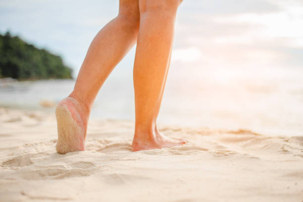 istock Woman walking on the beach at sunset. 998059042