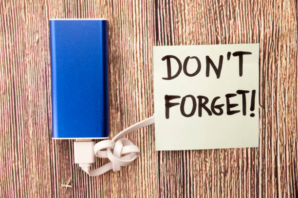 istock Blue colored Energy bank along with usb cable and a warning note Dont Forget is present.. There note in the picture remind someone about an important fact or detail 998059300