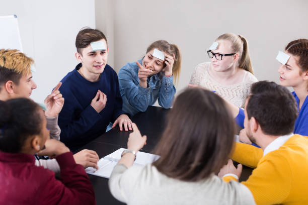 istock Classmates having round of guess-who game during class 998075324