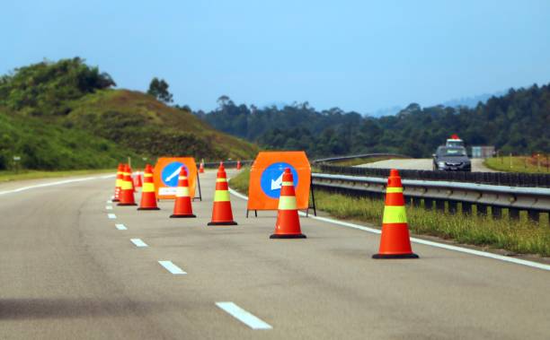 istock Traffic cones and a sign with a white arrow on highway 998087732