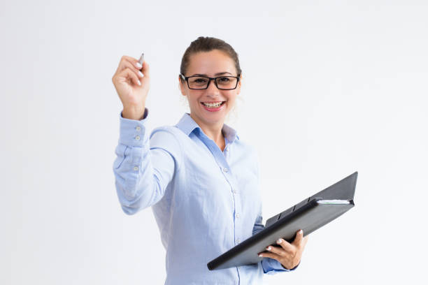 istock Smiling young woman holding file and writing in air 998090552