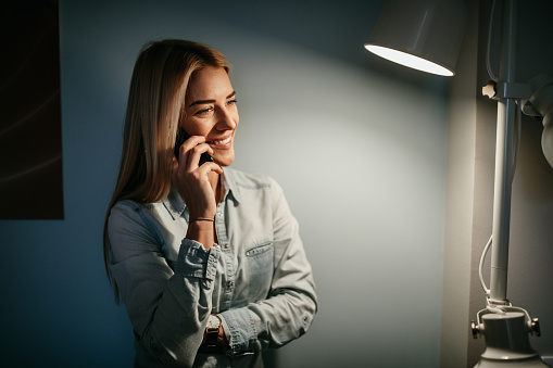 Attractive young woman talking on the phone at night