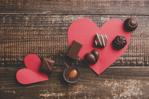 red heart and a lots of chocolate - valentines day red photography indoors imagens e fotografias de stock