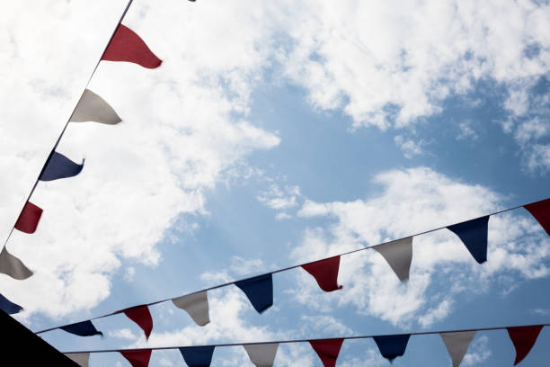 istock Multicolored Triangular Flags Hanging in the Sky at an Outdoor. Garland of bright colored developing in the wind against the background of the cloudy sky. 998101950