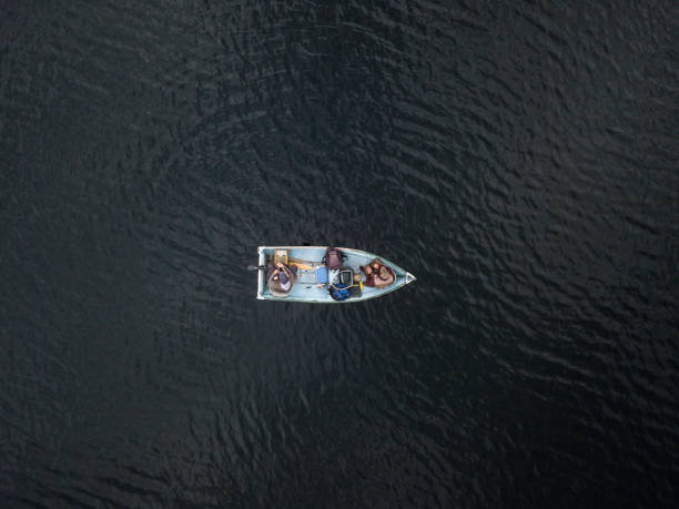 Aerial View of Fishermans Fishing From a Boat on Lake Aerial View of Fishermans Fishing From a Boat on lake in forest, Quebec, Canada rowing boat fishing stock pictures, royalty-free photos & images